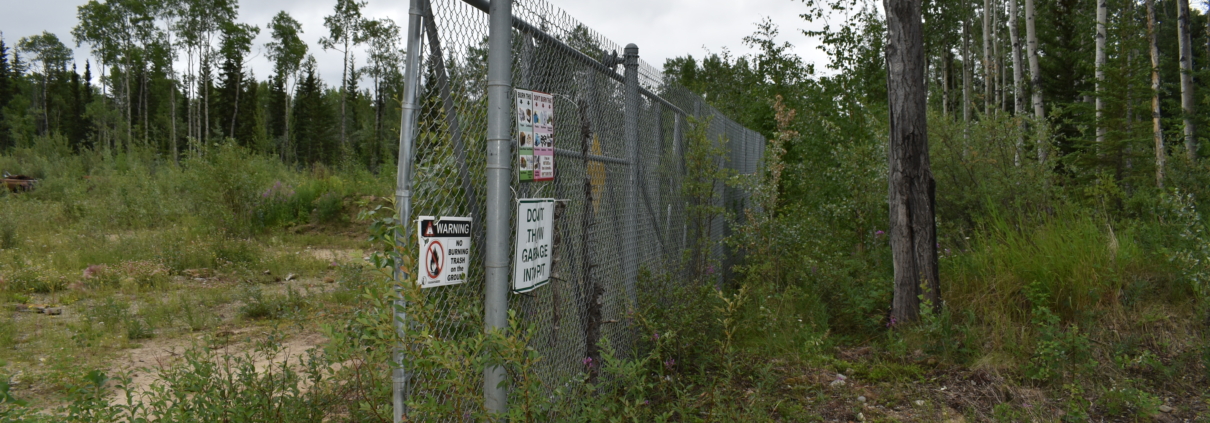 Photo of the fence around the landfill area of Dot Lake Village.