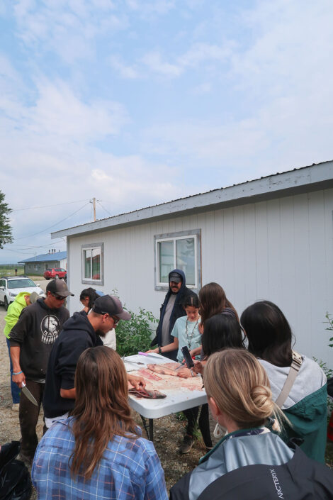 Learning to clean and prepare a fish at Culture Camp.